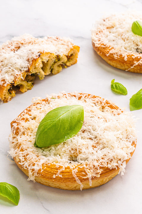 Image of a Pesto Parmesan Roll from Laura's Home Bakery, showcasing its soft, airy interior swirled with aromatic pesto and sprinkled with premium Parmesan cheese.
