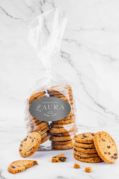 Packaged Chocolate Sea-Salt Sablés by Laura's Home Bakery, showcasing the exquisite cookies adorned with rich chocolate chips and delicate sea-salt crystals.