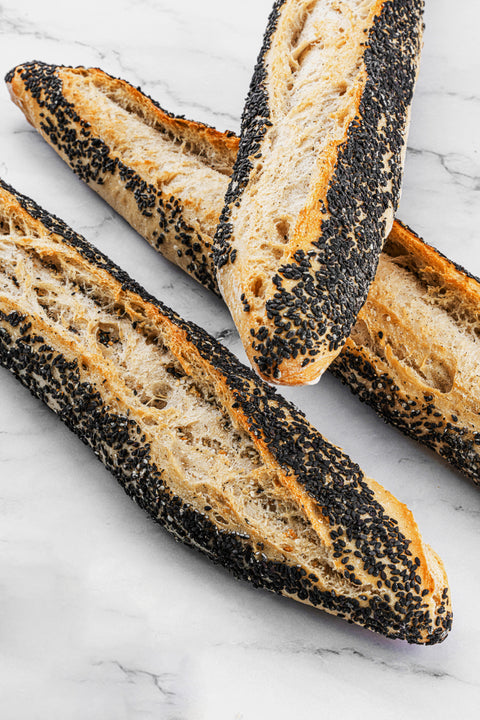 Image of a Black Sesame Sourdough Baguette, showcasing the delightful contrast of the golden-brown crust and the toasted black sesame seeds.