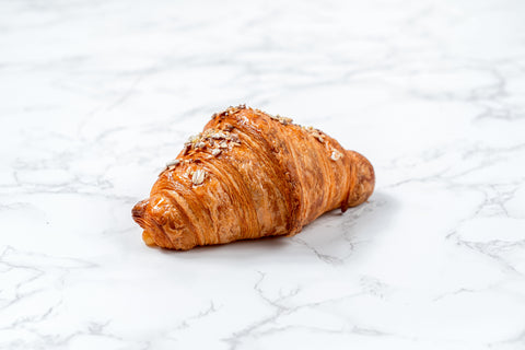 Image of an Emmental Croissant from Laura's Home Bakery, showcasing its flaky layers and a generous filling of Emmental cheese, perfectly baked to golden perfection.