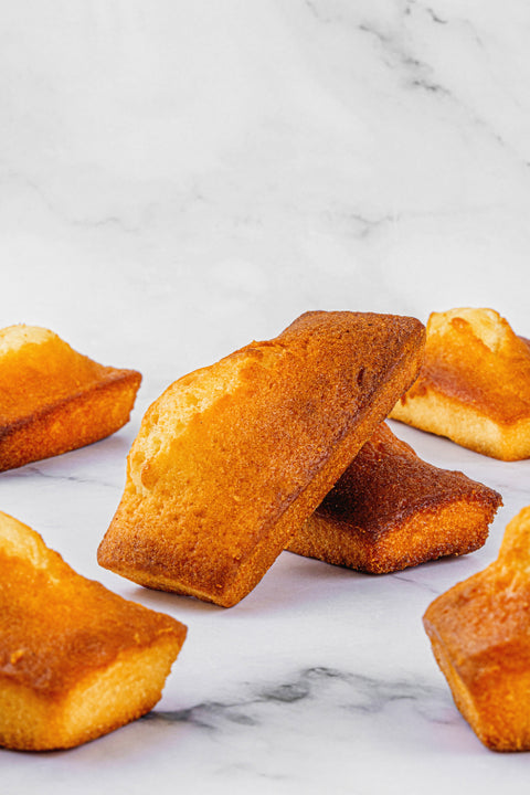 Image of Financiers from Laura's Home Bakery, showcasing their small, rectangular shape, moist almond-infused interior, and crisp, golden crust.