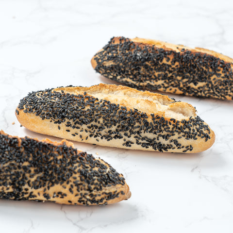 Image of a Mini Black Sesame Sourdough Baguette from Laura's Home Bakery, showcasing its rustic exterior and the subtle elegance of black sesame seeds mixed into the dough.