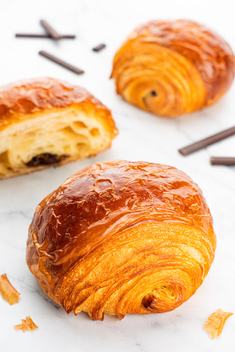 Image of Pain Au Chocolat from Laura's Home Bakery, showcasing their buttery, flaky layers and a luscious core of rich, velvety chocolate.
