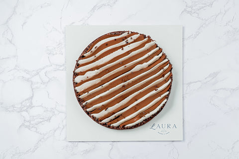 Top view Image of a Triple Chocolate Tart with White Vanilla Ganache and Chocolate Whipped Cream from Laura's Home Bakery, showcasing its luxurious toppings and decadent chocolate layers.