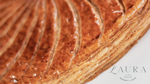 Close-up of a layered pastry with 'Laura' branding