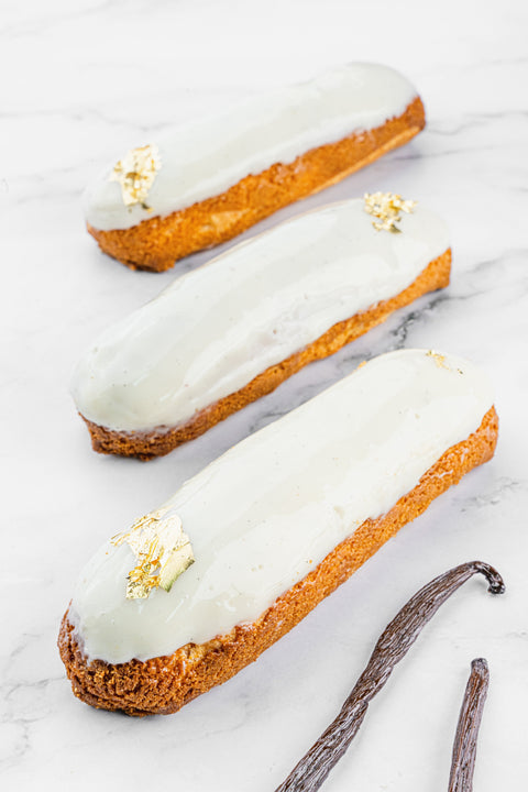 Image of an Éclair Vanilla from Laura's Home Bakery, showcasing its delicate choux pastry shell filled with velvety vanilla cream