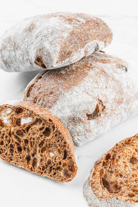 Image of a set of Cranberry Ciabatta Brown loaves from Laura's Home Bakery, showcasing their rustic brown crust and the sweet burst of cranberries embedded within.