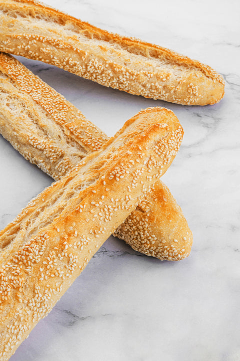 Image of an Artisan Sesame Sourdough Baguette, showcasing a golden crust, with sesame seeds adding a nutty touch