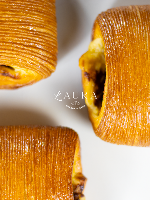 Close-up of baked items with a 'Laura' logo in the center.