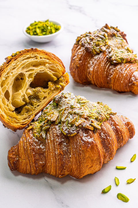 Image of Pistachio Croissant from Laura's Home Bakery, showcasing its nut-infused crushed pistachio filling and flaky, buttery layers.