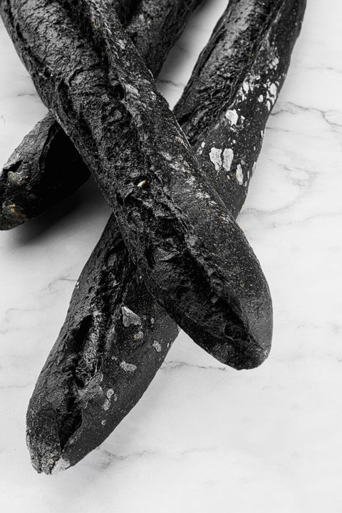 Image of Traditional Artisan Sourdough Charcoal Baguette from Laura's Home Bakery, showcasing its visually striking charcoal infusion and rustic crust.