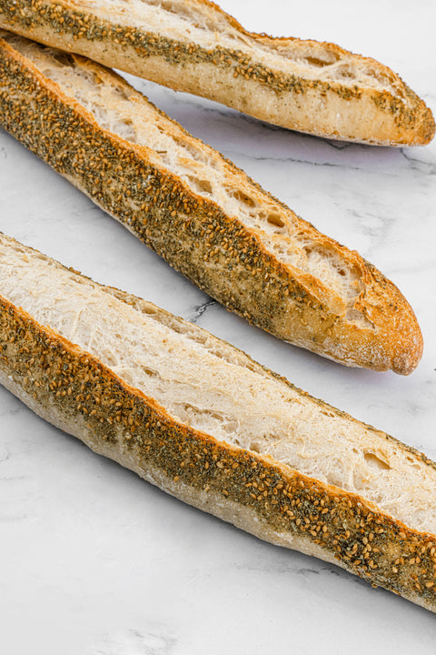 Image of Zaatar Sourdough Baguette from Laura's Home Bakery, showcasing its rustic crust and aromatic Zaatar seasoning