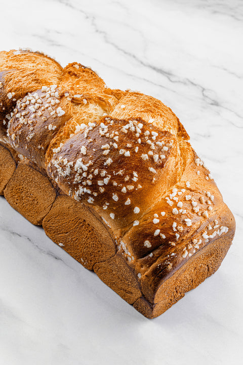 Image of a Sugar Brioche Braid Loaf, showcasing its rich, golden crust and soft, buttery interior, with subtle sugar pearls.