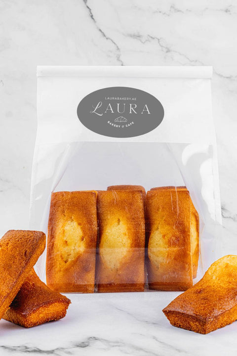 Image of package Financiers from Laura's Home Bakery, showcasing their small, rectangular shape, moist almond-infused interior, and crisp, golden crust.