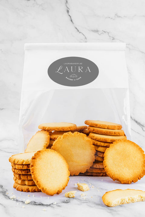 Close-up view of a stack of golden-brown Petit Beurre Biscuits from Laura's Home Bakery, highlighting their buttery texture and nostalgic charm.