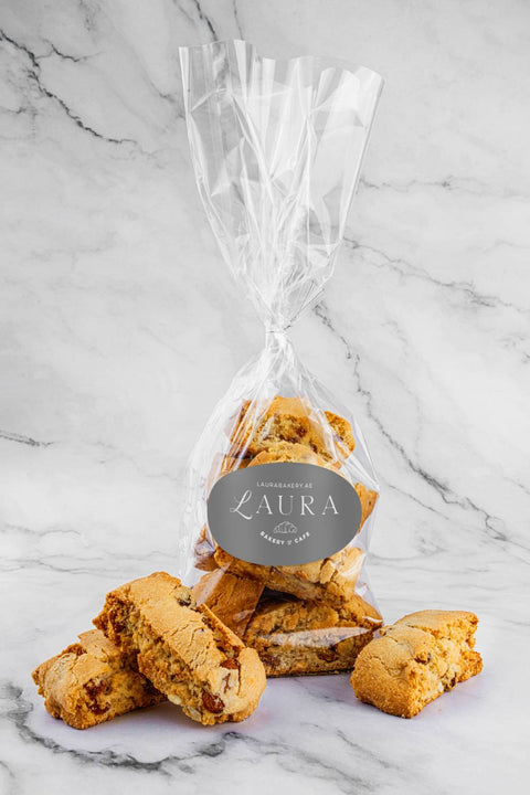 Almond Biscottis in a transparent packaging bag, showcasing the golden brown biscottis with visible almond pieces.