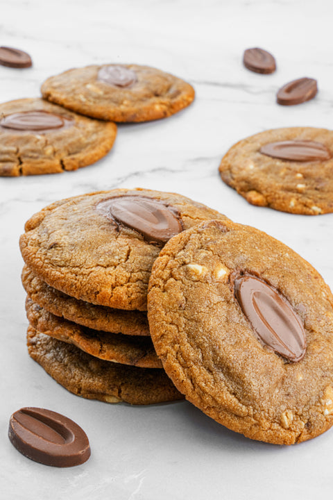 Image of Milk Chocolate Cookies from Laura's Home Bakery, showcasing their golden-brown, crinkled exterior studded with abundant milk chocolate chips.