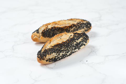 Image of a Mini Black Sesame Sourdough Baguette from Laura's Home Bakery, showcasing its rustic exterior and the subtle elegance of black sesame seeds mixed into the dough.