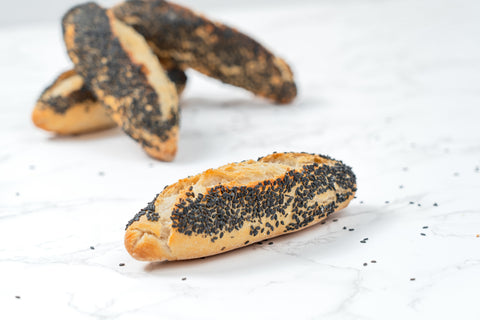 Image of a Mini Black Sesame Sourdough Baguette from Laura's Home Bakery, showcasing its rustic exterior and the subtle elegance of black sesame seeds mixed into the dough.