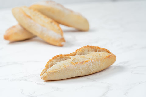 Image of a Mini Traditional Sourdough Baguette from Laura's Home Bakery, showcasing its rustic exterior and chewy, sourdough-infused interior