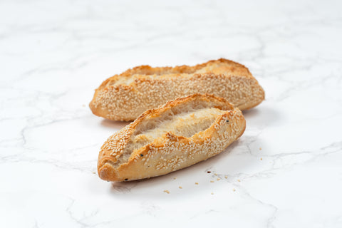 Image of a Mini White Sesame Sourdough Baguette from Laura's Home Bakery, showcasing its rustic exterior adorned with a delicate sprinkle of white sesame seeds