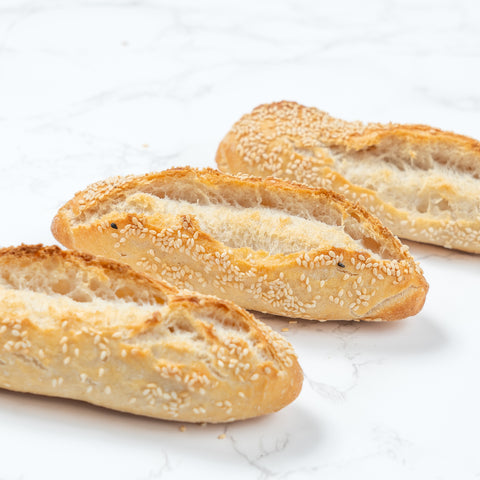 Side Image of a Mini White Sesame Sourdough Baguette from Laura's Home Bakery, showcasing its rustic exterior adorned with a delicate sprinkle of white sesame seeds