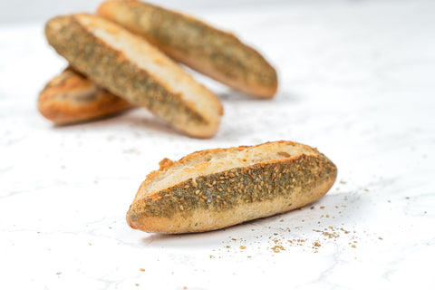 Full Image of a Mini Zaatar Sourdough Baguette from Laura's Home Bakery, showcasing its rustic exterior and the fragrant blend of za'atar herbs mixed into the dough.