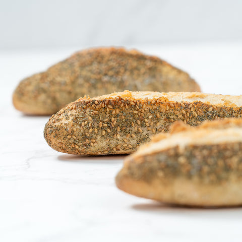 Side Image of a Mini Zaatar Sourdough Baguette from Laura's Home Bakery, showcasing its rustic exterior and the fragrant blend of za'atar herbs mixed into the dough.