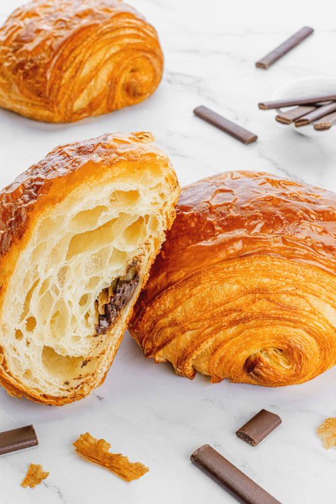 Close up Image of Pain Au Chocolat from Laura's Home Bakery, showcasing their buttery, flaky layers and a luscious core of rich, velvety chocolate.