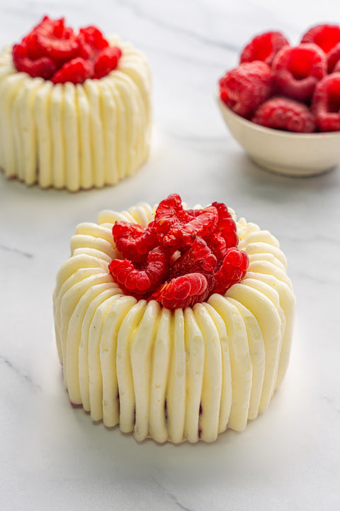 Image of Raspberry Charlottes from Laura's Home Bakery, showcasing their layers of velvety raspberry mousse and delicate ladyfingers, a visual delight.