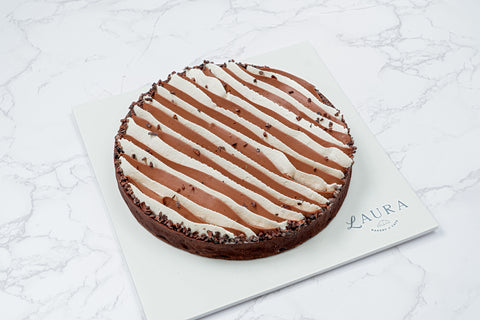 Image of a Triple Chocolate Tart with White Vanilla Ganache and Chocolate Whipped Cream from Laura's Home Bakery, showcasing its luxurious toppings and decadent chocolate layers.
