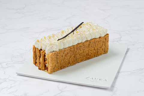 Image of a Vanilla Mille Feuille from Laura's Home Bakery, showcasing its delicate layers of flaky puff pastry and velvety vanilla custard, finished with a dusting of powdered sugar.