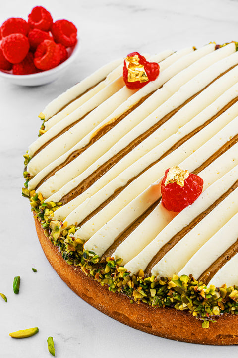 Image of Pistachio and Raspberry Tart from Laura's Home Bakery, showcasing its harmonious combination of crushed pistachios, ripe raspberries, and delicate pastry crust.