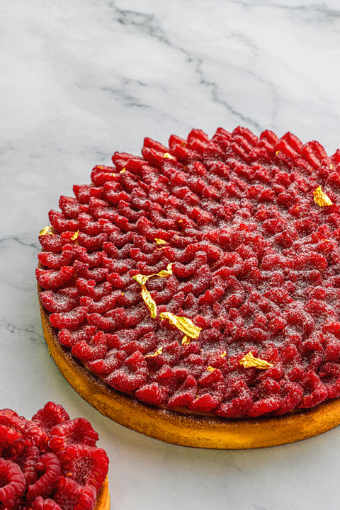 Image of Raspberry Tart from Laura's Home Bakery, showcasing a medley of plump and succulent raspberries atop a delicate pastry crust, a visual delight.