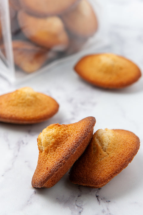 Close-up image of freshly baked Madeleines from Laura's Home Bakery, showcasing their golden-brown exteriors with delicate ridges.