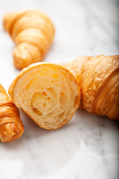 Close-up view revealing the tender and buttery interior layers of a Plain Pure Butter Croissant from Laura's Home Bakery, a delicious and flaky masterpiece.